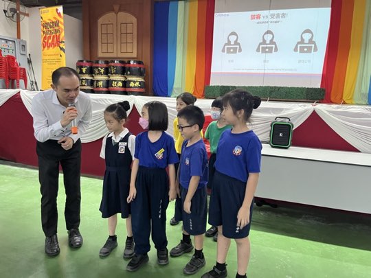 Ts. Lukas J. Tan delivering a scam-awareness talk at SJKC Mah Hua
