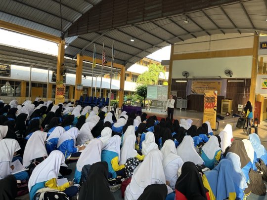 Ts. Lukas J. Tan delivering a scam-awareness talk at SMK Telok Air Tawar