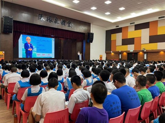 Ts. Lukas J. Tan delivering a scam-awareness talk at SMK Jit Sin