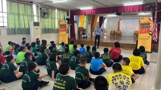Ts. Lukas J. Tan delivering a scam-awareness talk at SJKC Heng Ee