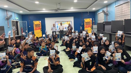 Ts. Lukas J. Tan delivering a scam-awareness talk at SK Permatang Binjai