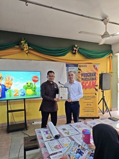 Ts. Lukas J. Tan delivering a scam-awareness talk at SK Pulau Mertajam