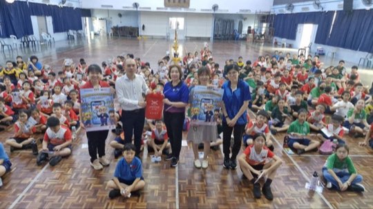 A school hall full of students learning about scams